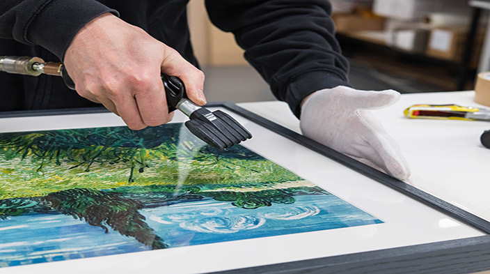 About Tate Custom Prints Gloved hands assembling a black framed art print with care.